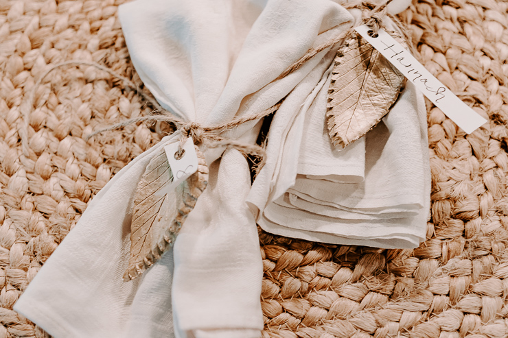 view of napkins tied with jute twine and a clay leaf place card