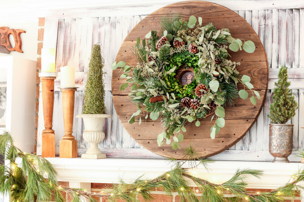 mantle decorated for Christmas with green wreath on cable reel