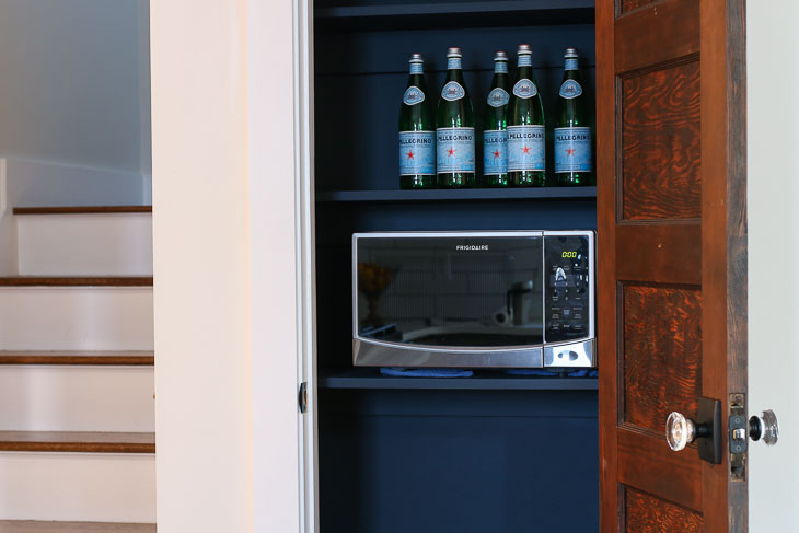 Pantry with Reclaimed door and microwave. Black walls