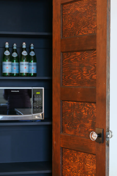 Pantry with Reclaimed door and microwave. Black walls