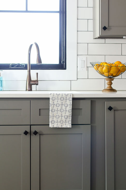 Plygem Mira black framed casement window over bronze faucet and gray cabinets