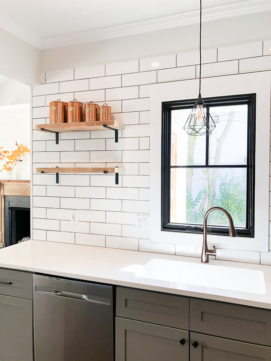 Plygem Mira black framed casement window over bronze faucet subway tile open shelving