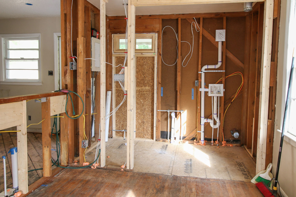 open framed wall looking into new powder room and laundry room